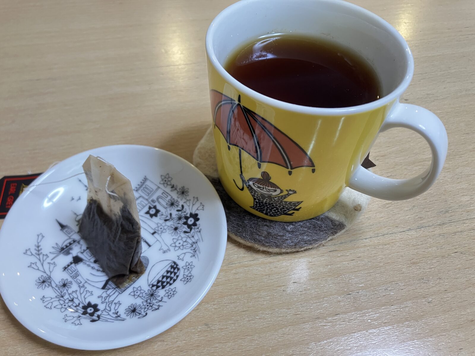 紅茶のマグカップの横で、エミリアにティーバッグを乗せたお茶の時間