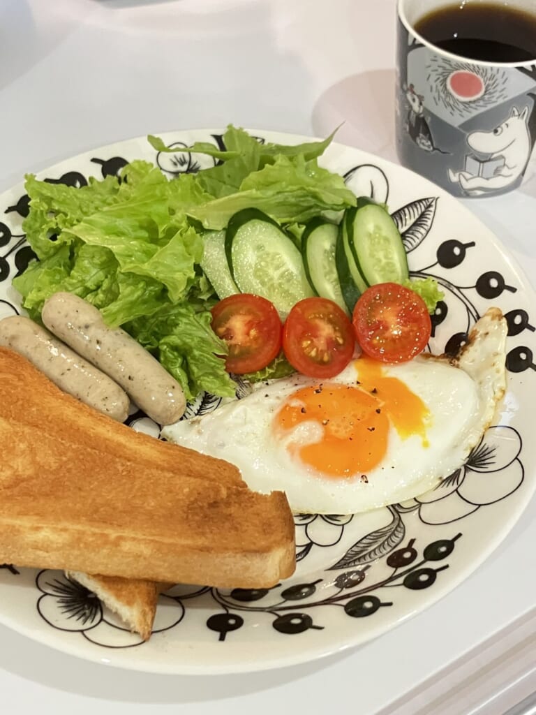 ブラックパラティッシ26cmのプレートに、トースト、目玉焼き、ウインナー、サラダをのせた朝ごはんのワンプレート